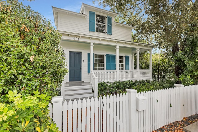 view of front facade featuring covered porch and a fenced front yard