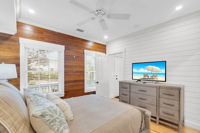 bedroom with wooden walls, recessed lighting, light wood-style flooring, and ceiling fan