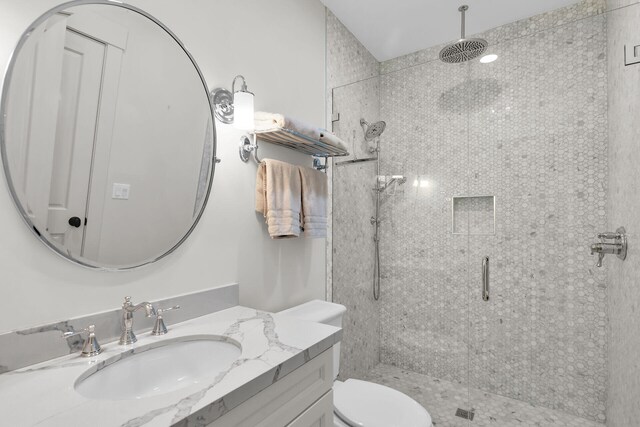 full bath featuring a stall shower, vanity, and toilet