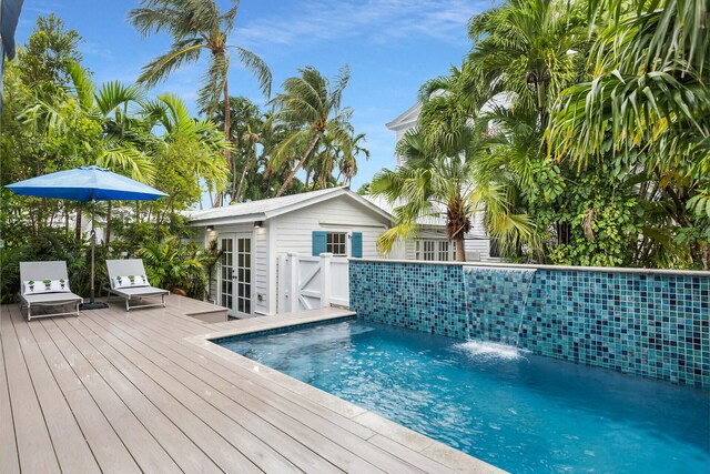outdoor pool featuring a wooden deck and french doors
