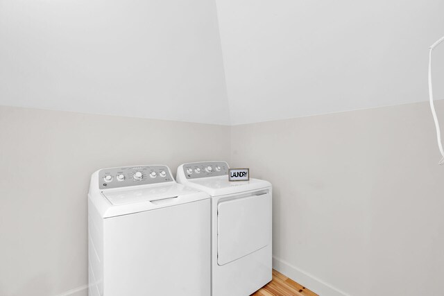 laundry room with separate washer and dryer, baseboards, and light wood finished floors