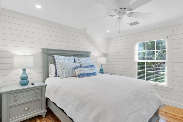 bedroom featuring wood walls, wood finished floors, recessed lighting, and a ceiling fan