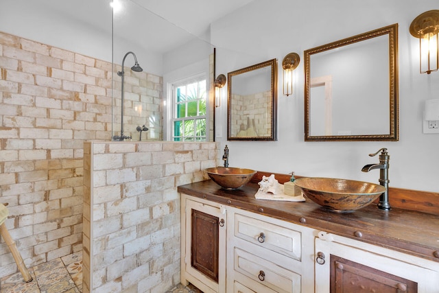 full bathroom featuring double vanity, walk in shower, and a sink