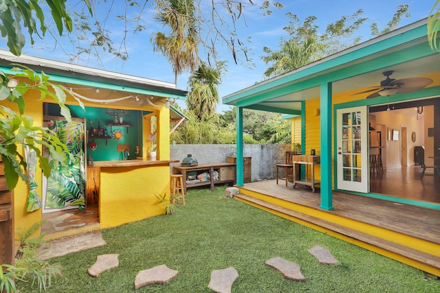 view of yard with ceiling fan, a deck, and fence