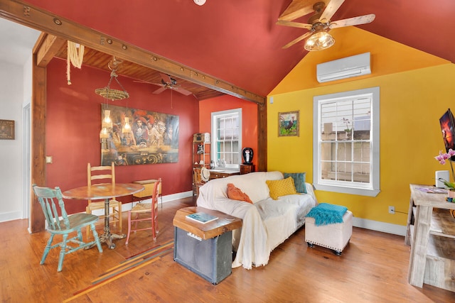 living area featuring ceiling fan, lofted ceiling with beams, wood finished floors, baseboards, and an AC wall unit