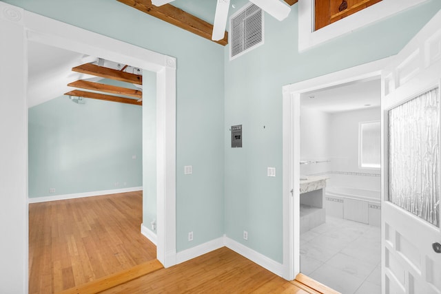 hall featuring beamed ceiling and light wood-type flooring