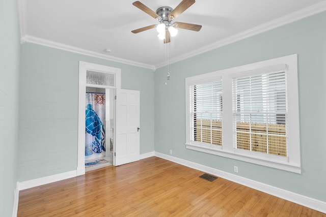 unfurnished bedroom with ornamental molding, hardwood / wood-style floors, and ceiling fan