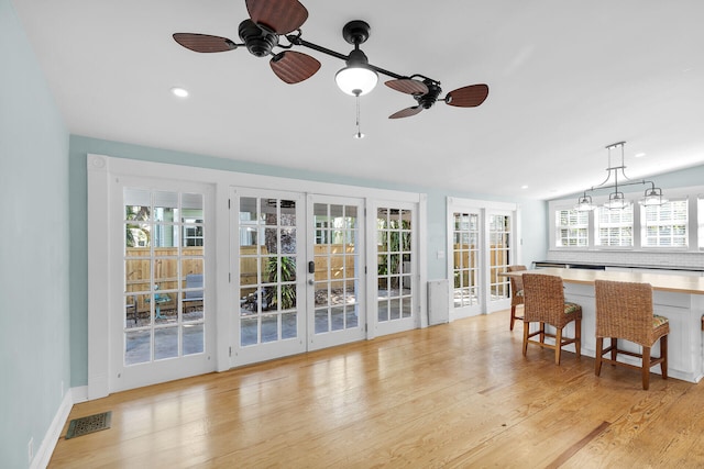 living room featuring light hardwood / wood-style floors, french doors, and ceiling fan