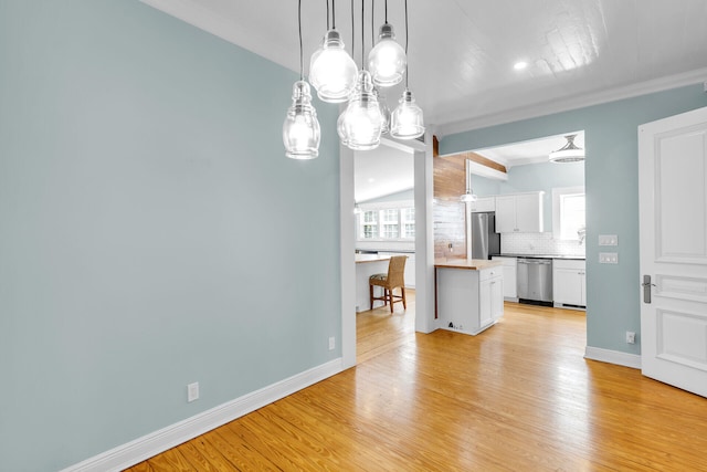 unfurnished dining area with crown molding and light hardwood / wood-style floors