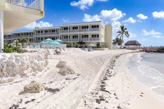 view of property with a water view and a view of the beach