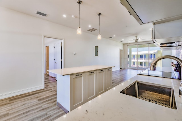 kitchen with a sink, a ceiling fan, light wood-style flooring, and visible vents