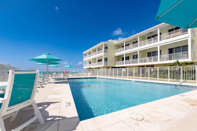 pool featuring fence and a patio area