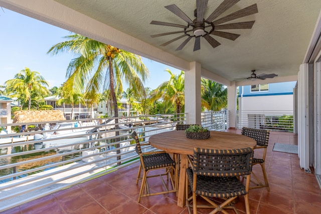 view of patio / terrace with a balcony, ceiling fan, and a water view