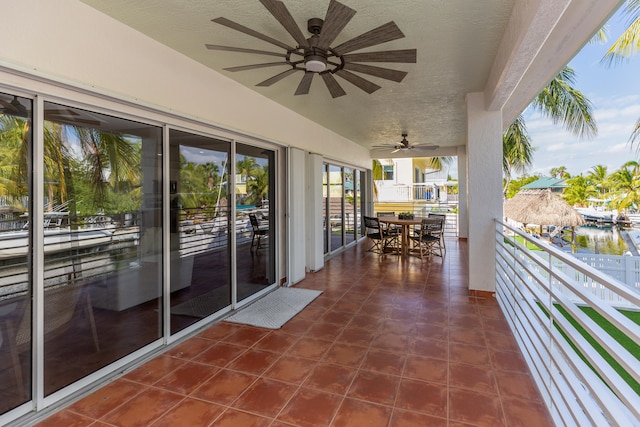 balcony with ceiling fan and a water view