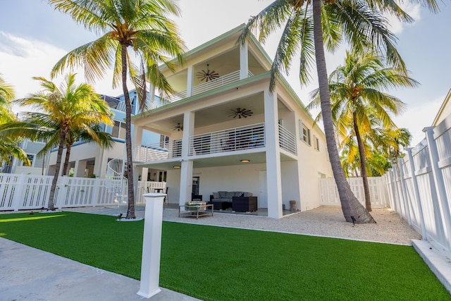 back of house with a patio, a balcony, outdoor lounge area, a yard, and ceiling fan