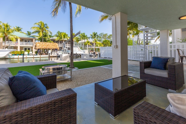 view of patio / terrace featuring an outdoor living space with a fire pit and a water view