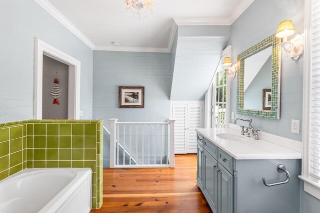 bathroom with vanity, a tub to relax in, crown molding, and hardwood / wood-style floors