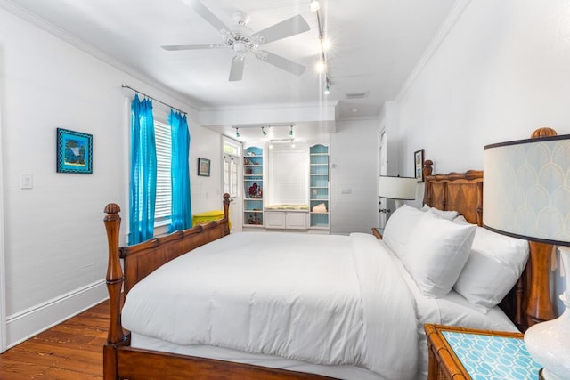 bedroom with crown molding, ceiling fan, rail lighting, and dark wood-type flooring