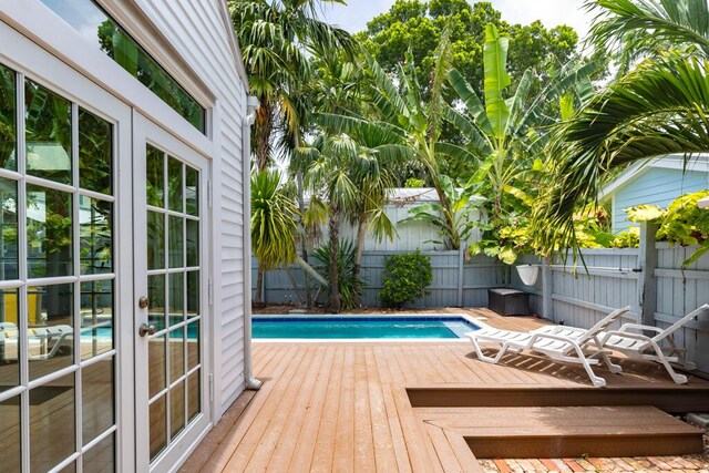 view of swimming pool featuring a wooden deck and french doors