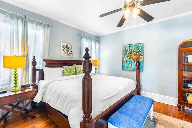 bedroom featuring wood-type flooring, ornamental molding, and ceiling fan