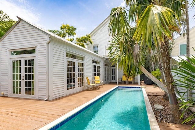 view of swimming pool featuring a wooden deck and french doors