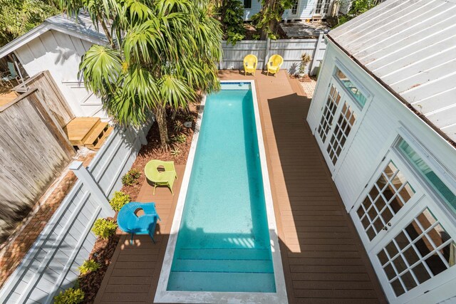 view of swimming pool featuring a wooden deck and french doors