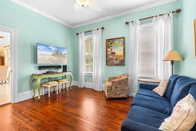 living room featuring dark hardwood / wood-style flooring, crown molding, and ceiling fan