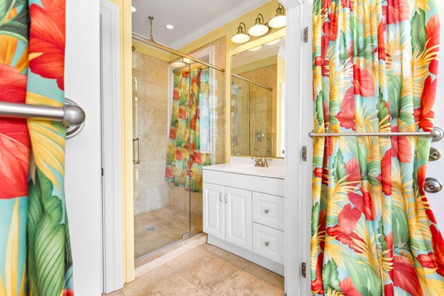 bathroom featuring ornamental molding, tile patterned floors, tiled shower, and vanity