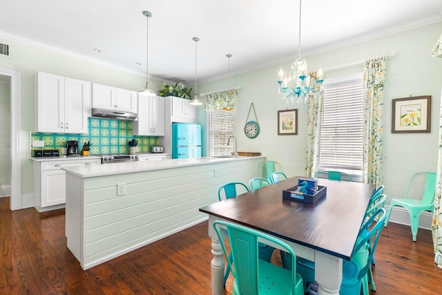 kitchen with decorative backsplash, white cabinets, dark hardwood / wood-style flooring, and decorative light fixtures