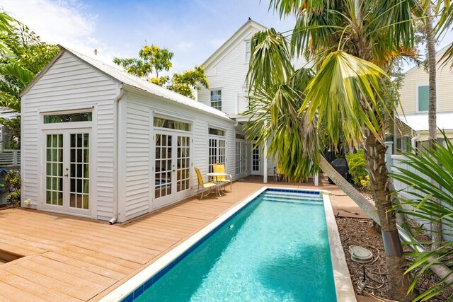 exterior space featuring french doors, a deck, and an outbuilding