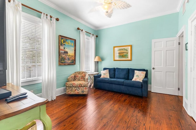 living room with dark wood-type flooring, ornamental molding, and ceiling fan