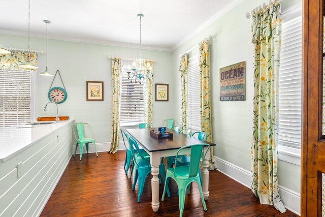 dining area featuring crown molding, sink, a chandelier, and dark hardwood / wood-style flooring