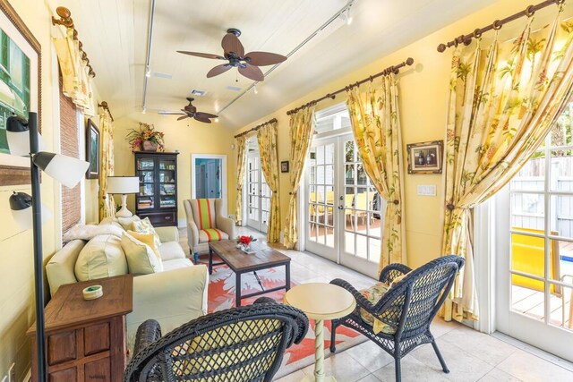 sunroom / solarium featuring track lighting, ceiling fan, and french doors