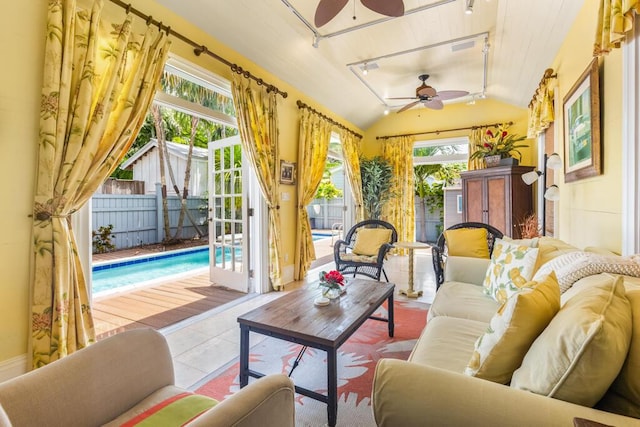 sunroom featuring lofted ceiling, track lighting, and ceiling fan