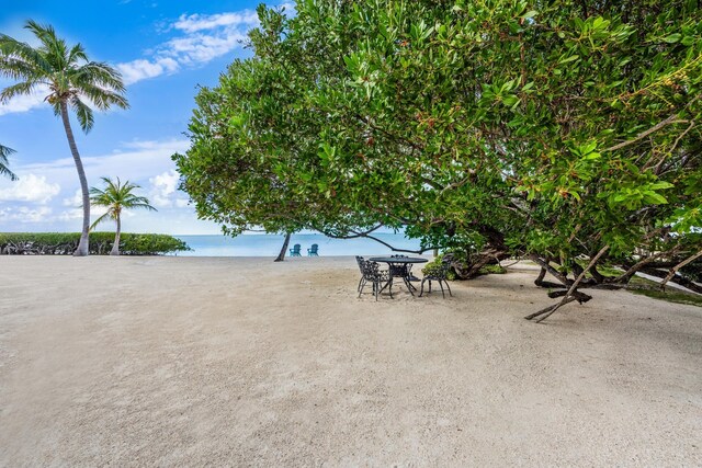 view of patio with a beach view and a water view