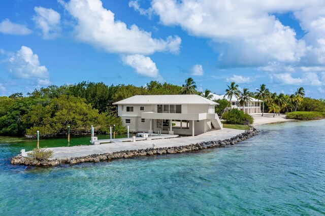 rear view of property featuring a water view and a patio area