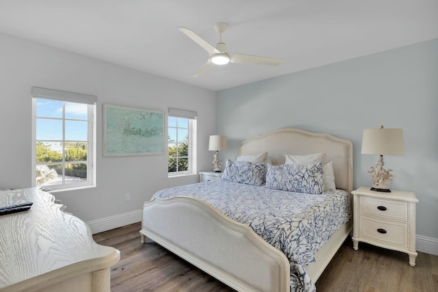 bedroom with ceiling fan, dark wood-style flooring, and baseboards