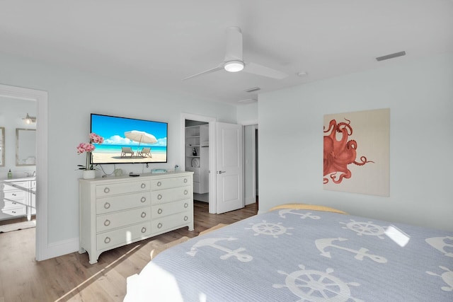 bedroom with a ceiling fan, visible vents, light wood-style flooring, and a spacious closet