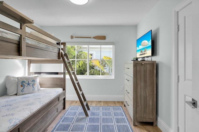 bedroom with light wood finished floors and baseboards
