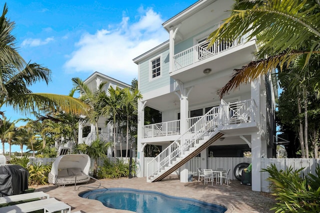 rear view of house with a patio area, stairs, fence, and a fenced in pool