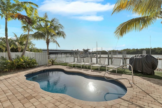 view of swimming pool with a fenced backyard, a patio area, a grill, and a fenced in pool