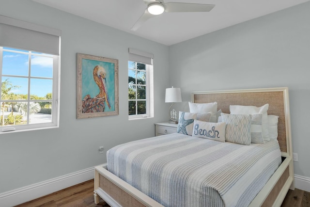 bedroom with multiple windows, baseboards, and wood finished floors