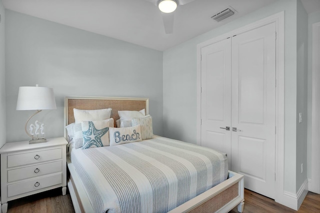 bedroom featuring baseboards, visible vents, dark wood-style flooring, and a closet