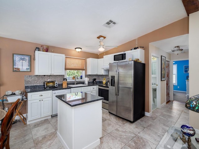 3806 Dyer Rd, Big Pine, FL 33043 - kitchen with stainless steel appliances, a sink, decorative backsplash, and white cabinetry