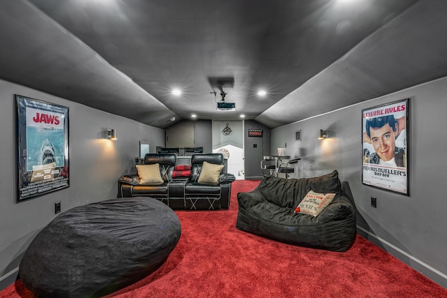 home theater room featuring vaulted ceiling and carpet flooring