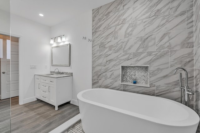 bathroom featuring vanity, hardwood / wood-style floors, and a tub