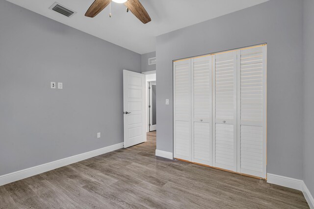 unfurnished bedroom featuring ceiling fan, light wood-type flooring, and a closet