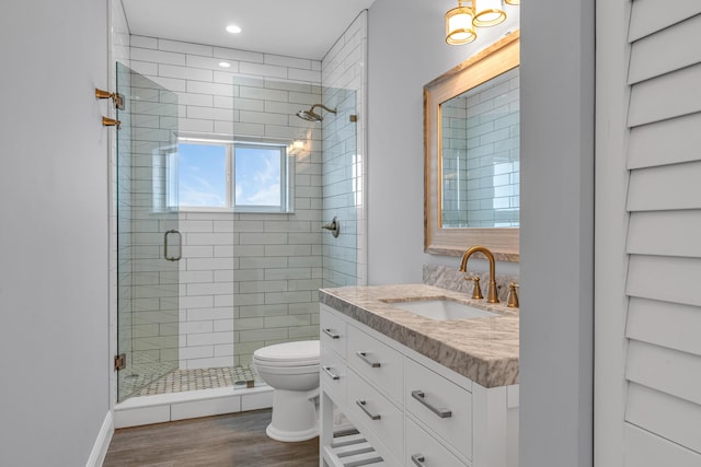 bathroom with vanity, toilet, hardwood / wood-style floors, and a shower with shower door