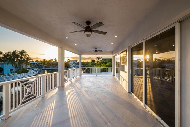 deck at dusk featuring ceiling fan