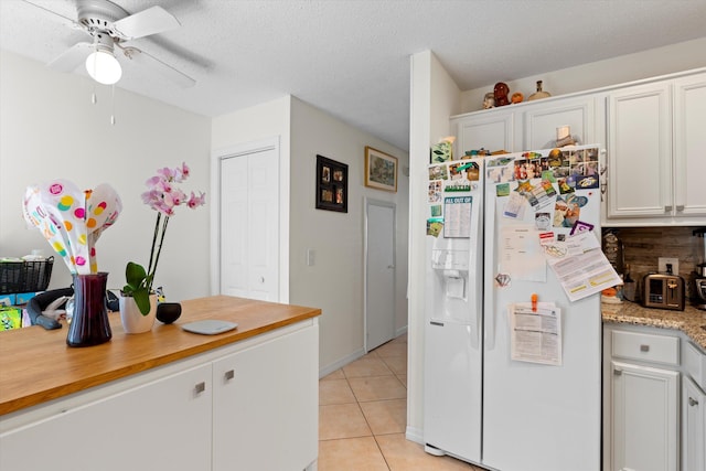 3397 Northside Dr Unit 4, Key West, FL 33040 - kitchen featuring white fridge with ice dispenser, light countertops, light tile patterned flooring, a ceiling fan, and white cabinets